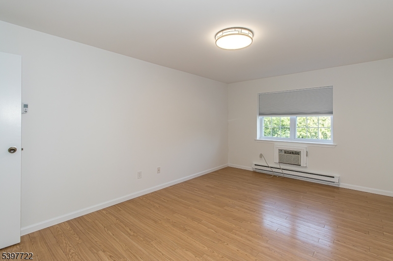 530 Park Avenue, Unit 214 Scotch Plains, NJ 07076 - Photo 15 of 17 an empty room with wooden floor and windows
