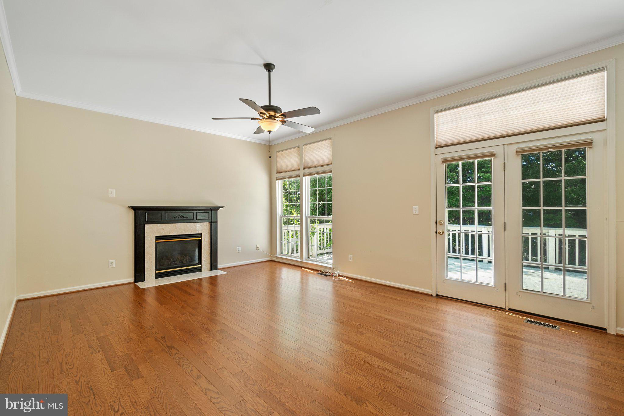 21255 Olive Green Court Ashburn, VA 20147 - Photo 12 of 32 a view of an empty room with wooden floor fireplace and a window