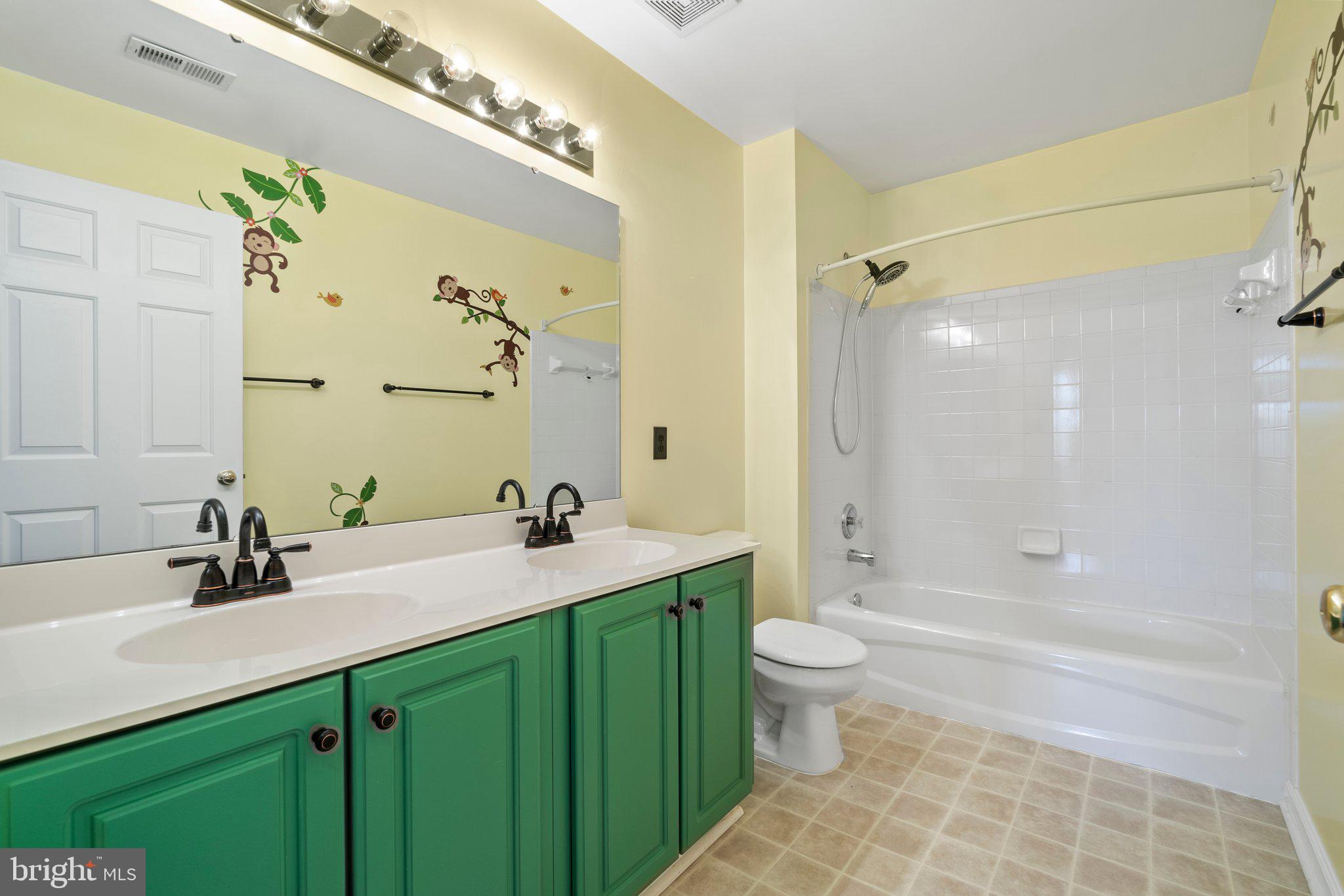 21255 Olive Green Court Ashburn, VA 20147 - Photo 26 of 32 a bathroom with a double vanity sink toilet mirror and bathtub