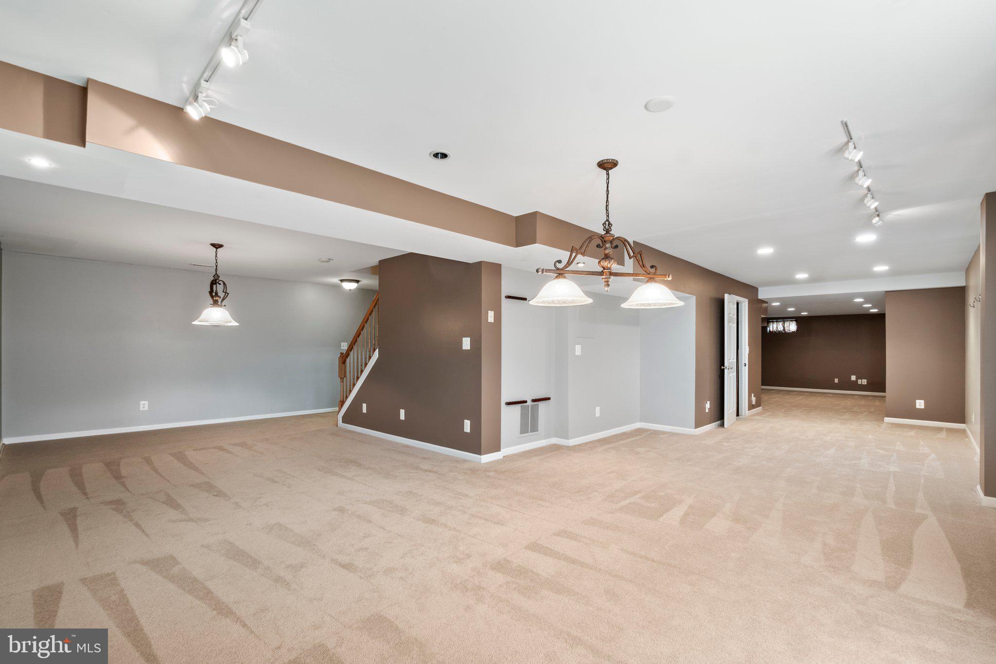 21255 Olive Green Court Ashburn, VA 20147 - Photo 27 of 32 a view of a hallway with a room and chandelier fan