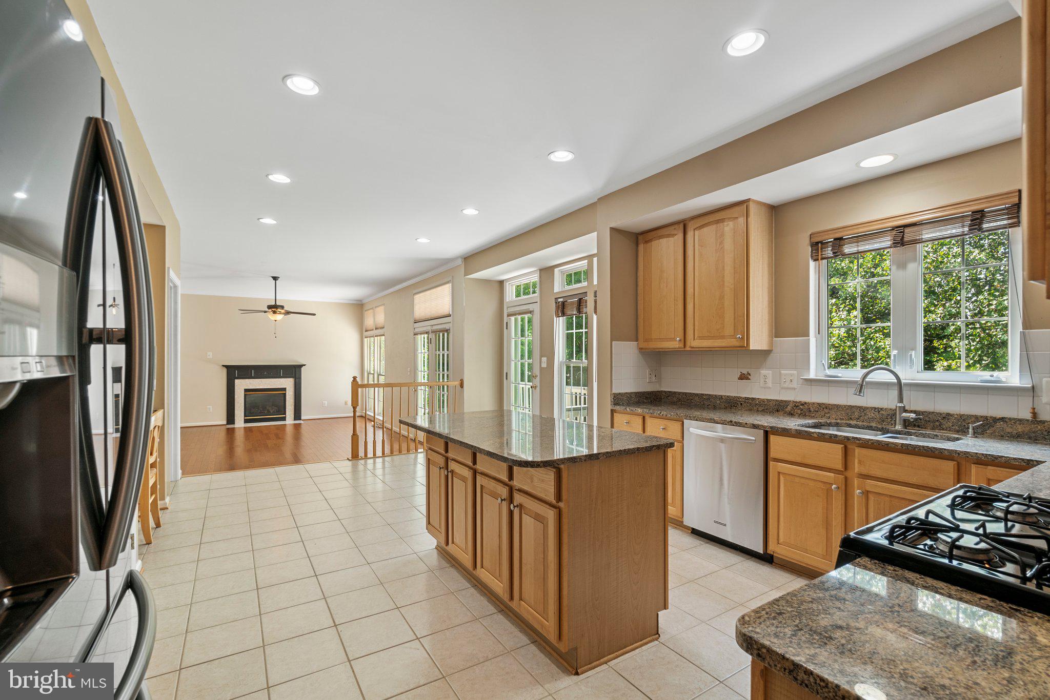 21255 Olive Green Court Ashburn, VA 20147 - Photo 3 of 32 a kitchen with stainless steel appliances granite countertop a refrigerator a stove and a sink with wooden floor