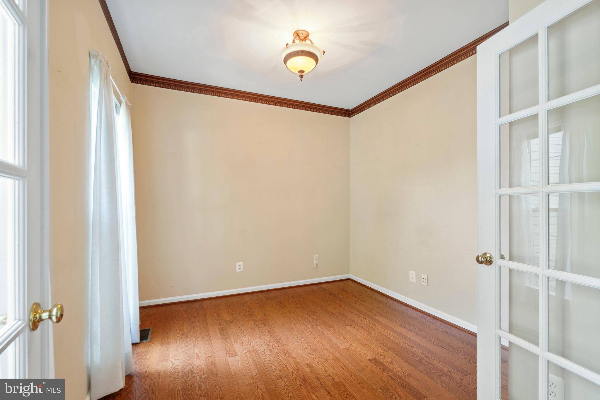 21255 Olive Green Court Ashburn, VA 20147 - Photo 5 of 32 a view of an empty room with wooden floor and a window