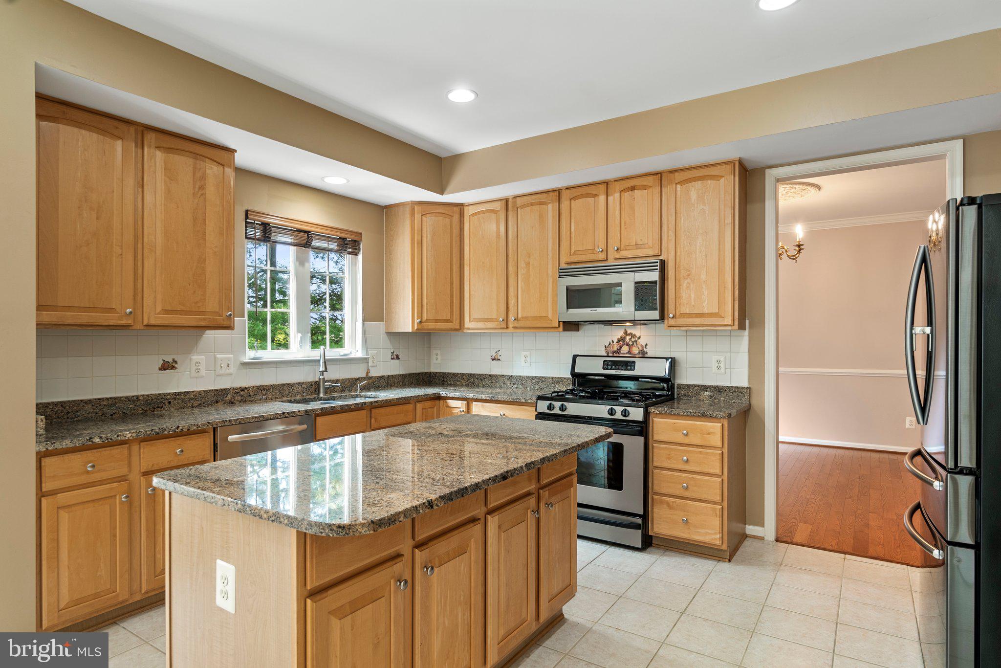 21255 Olive Green Court Ashburn, VA 20147 - Photo 9 of 32 a kitchen with stainless steel appliances granite countertop a stove top oven a sink and dishwasher