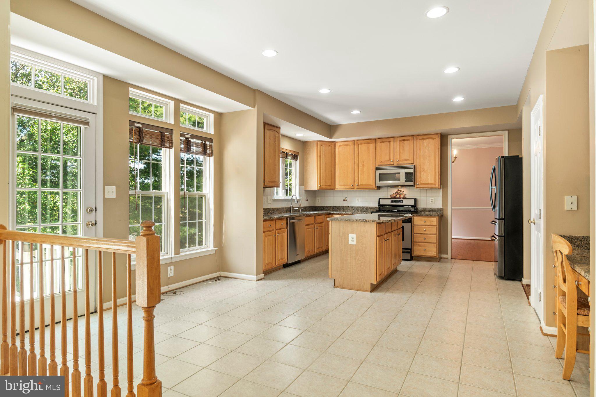 21255 Olive Green Court Ashburn, VA 20147 - Photo 10 of 32 a kitchen with a sink a counter top space stainless steel appliances cabinets and a large window