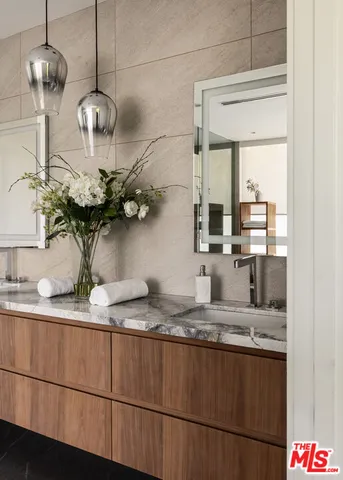 a bathroom with a granite countertop sink a mirror and vanity