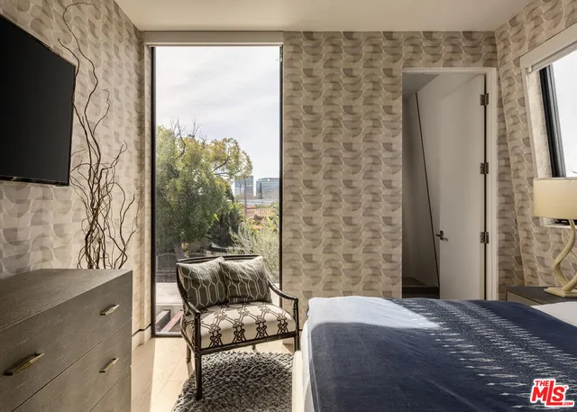 a bedroom with a bed and a flat tv screen on dresser