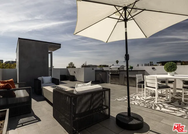 a dinning table and chairs under an umbrella