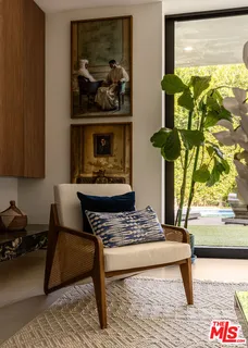 a living room with furniture and a painting on the wall