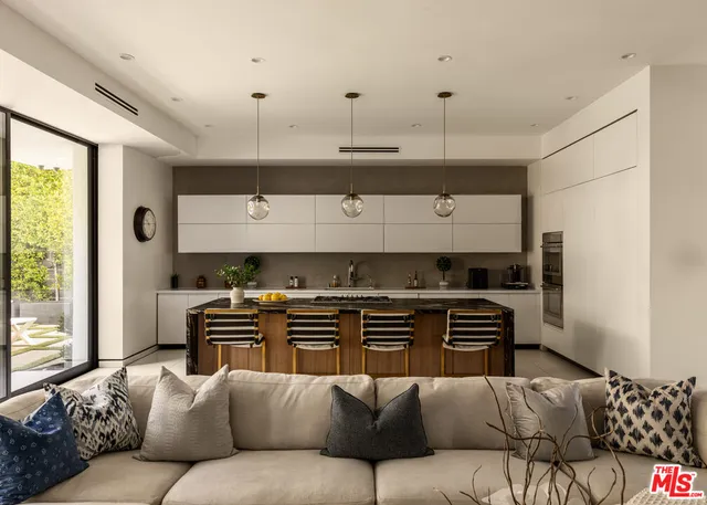 a living room with furniture a flat screen tv and a window