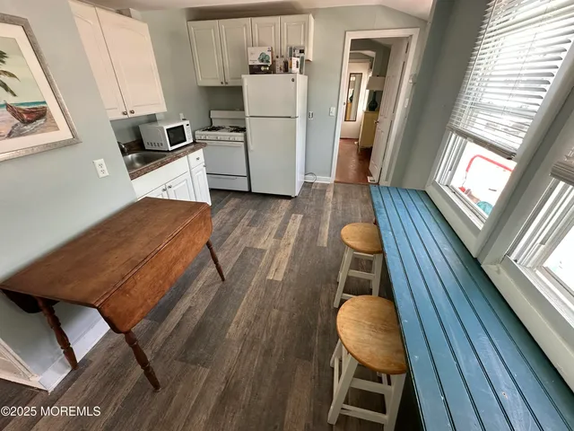 a kitchen with wooden floors and refrigerator