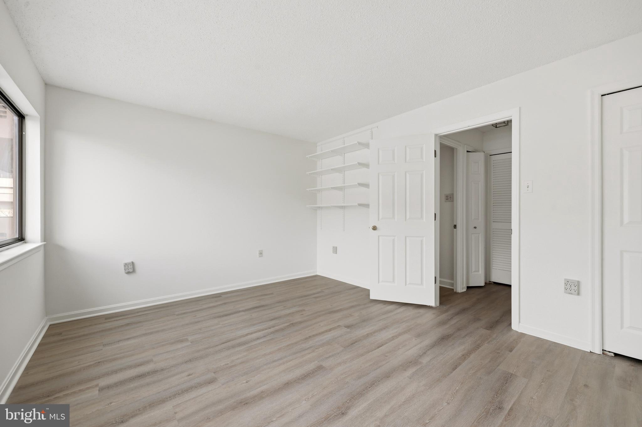 1301 North Courthouse Road, Unit 1205 Arlington, VA 22201 - Photo 12 of 33 an empty room with wooden floor & windows