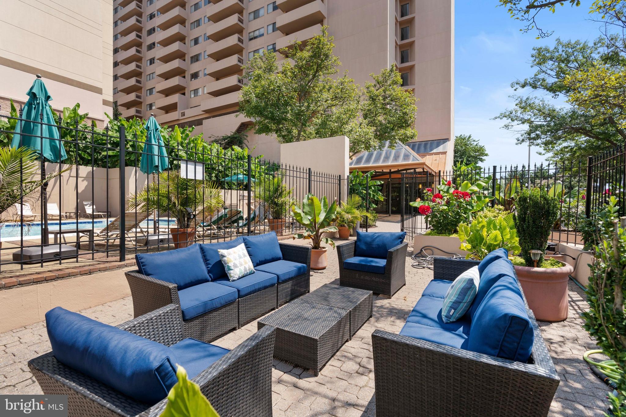 1301 North Courthouse Road, Unit 1205 Arlington, VA 22201 - Photo 24 of 30 a view of a patio with couches a table and chairs and potted plants