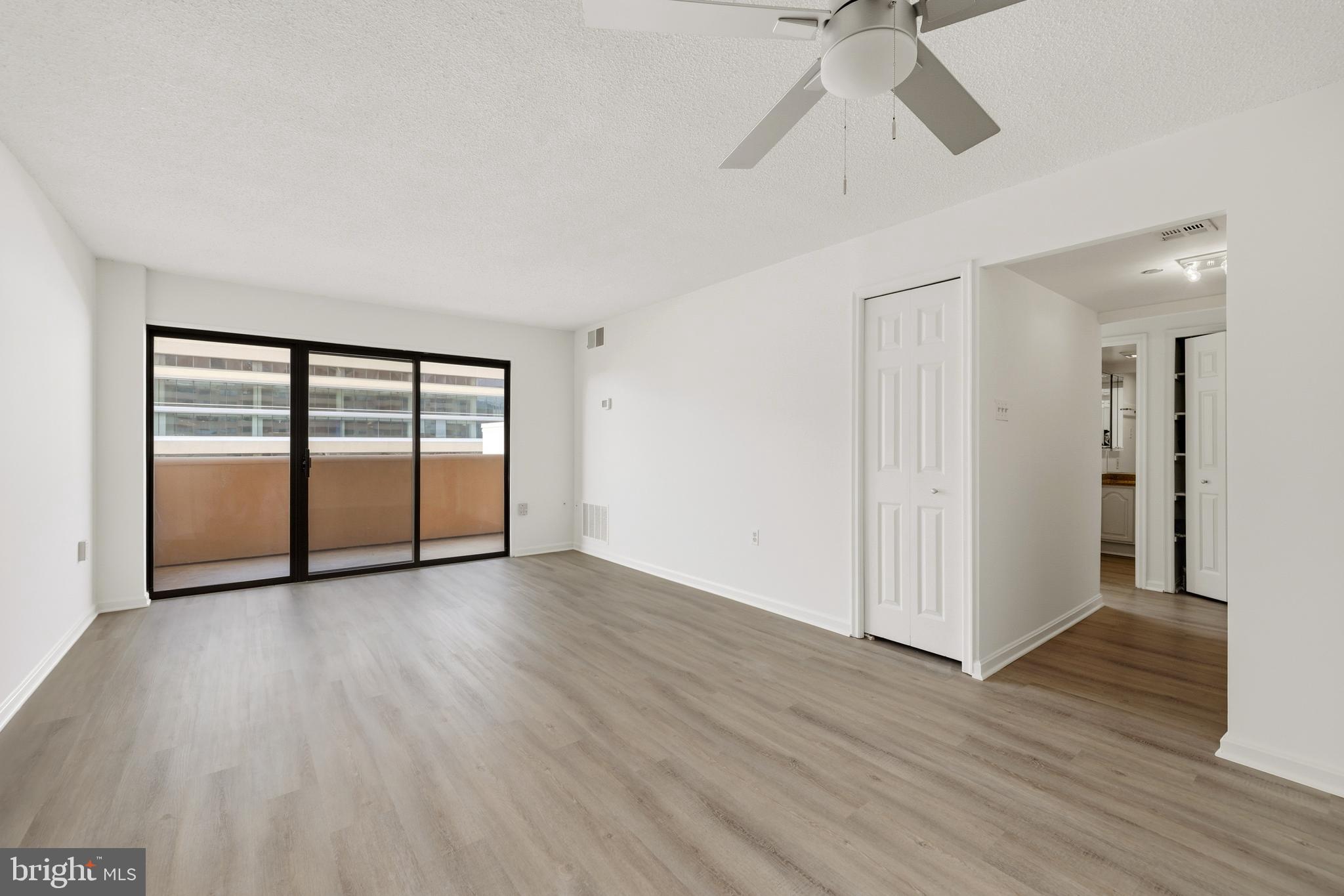 1301 North Courthouse Road, Unit 1205 Arlington, VA 22201 - Photo 7 of 33 a view of empty room with wooden floor and ceiling fan