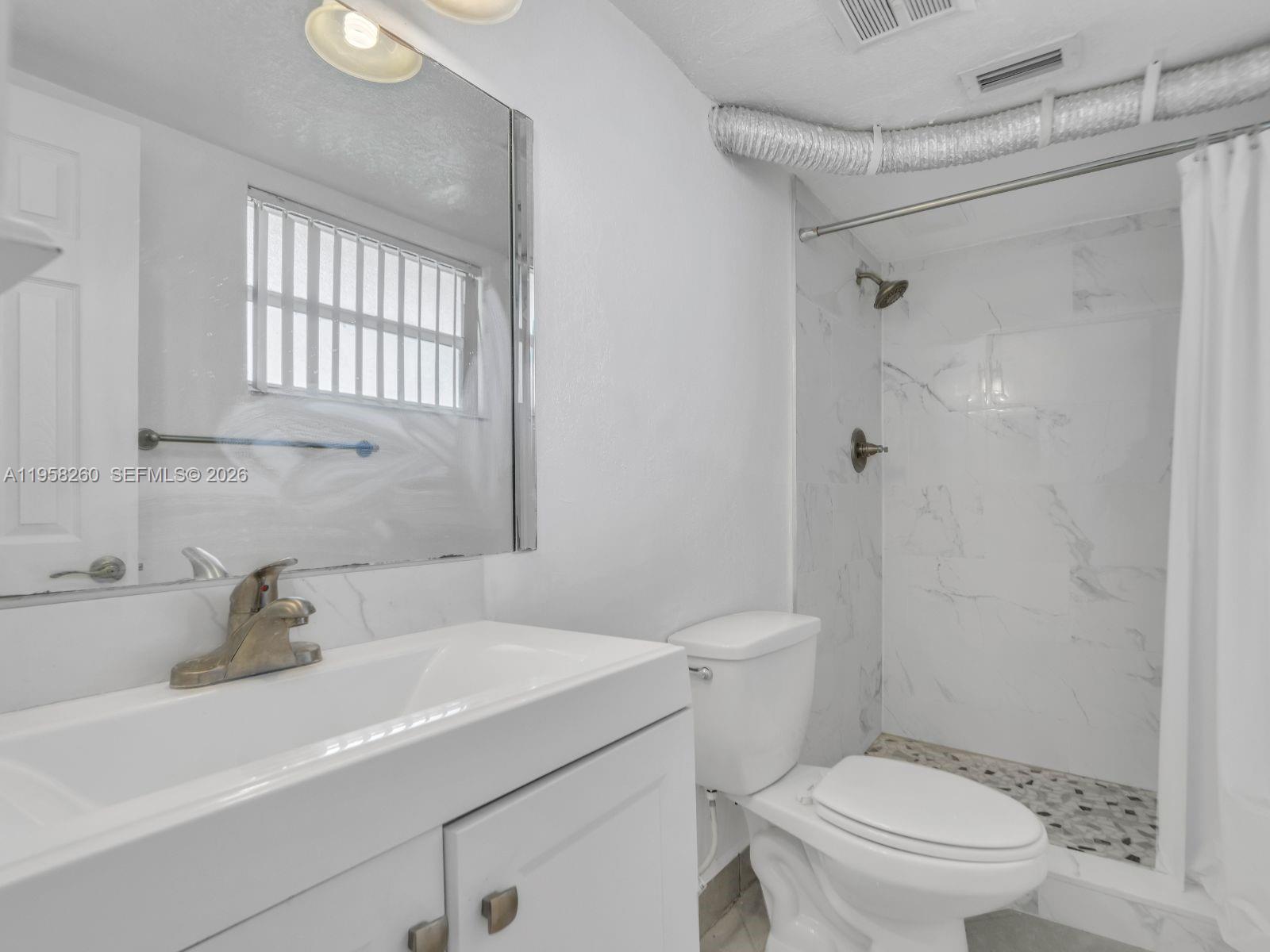 8601 Southwest 94th Street, Unit 104W Miami, FL 33156 - Photo 14 of 29 a bathroom with a sink a toilet and shower