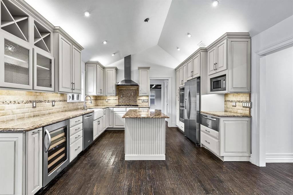 a kitchen with stainless steel appliances granite countertop a kitchen island hardwood floor sink and stove