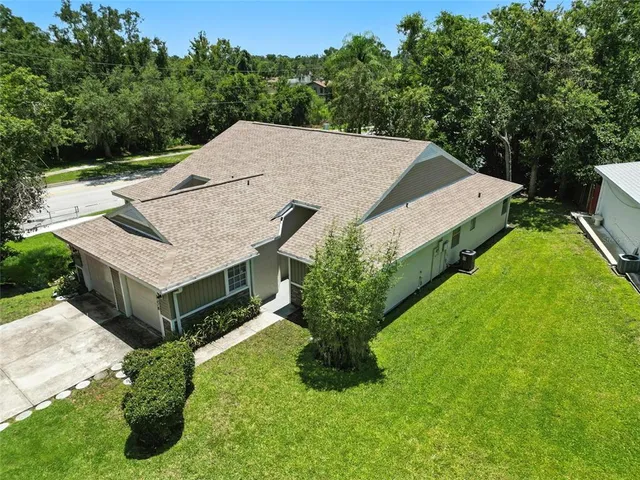 a aerial view of a house with a yard table and chairs