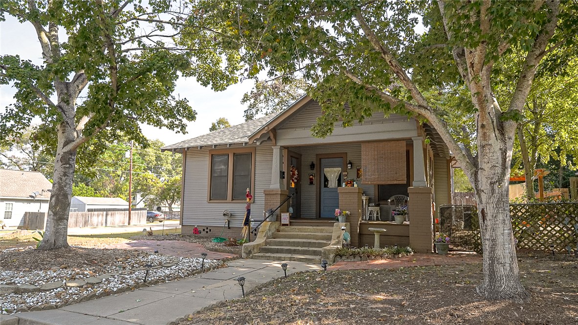 a view of a house with a tree in front of it