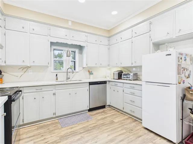 a kitchen with white cabinets white appliances and sink