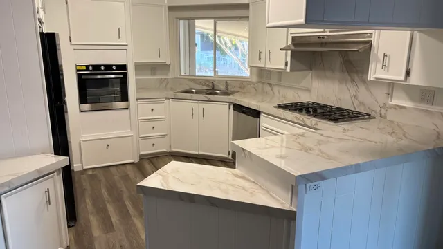 a kitchen with a sink stove top oven and cabinets