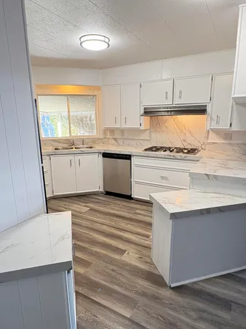 a kitchen with granite countertop white cabinets and white appliances