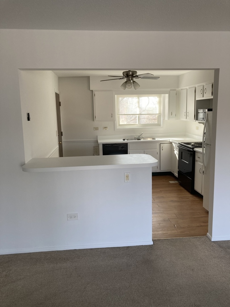 718 Cobblestone Circle, Unit D Glenview, IL 60025 - Photo 4 of 9 a large white kitchen with cabinets