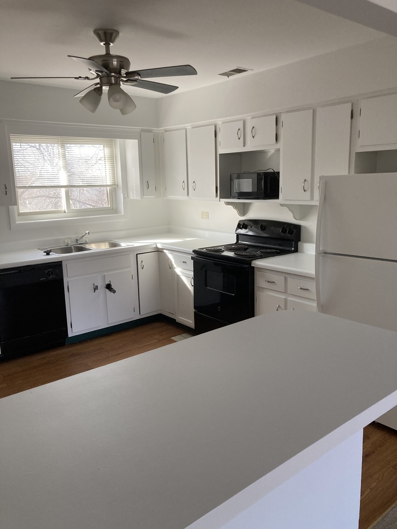718 Cobblestone Circle, Unit D Glenview, IL 60025 - Photo 5 of 9 a kitchen with granite countertop white cabinets white stainless steel appliances and a refrigerator