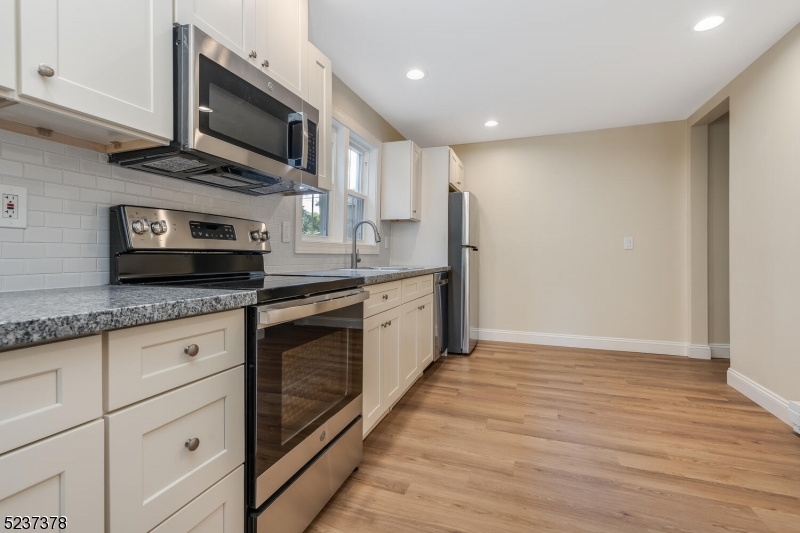 13 Maple Street Milford, NJ 08848 - Photo 15 of 20 a kitchen with stainless steel appliances granite countertop a stove a sink and a microwave
