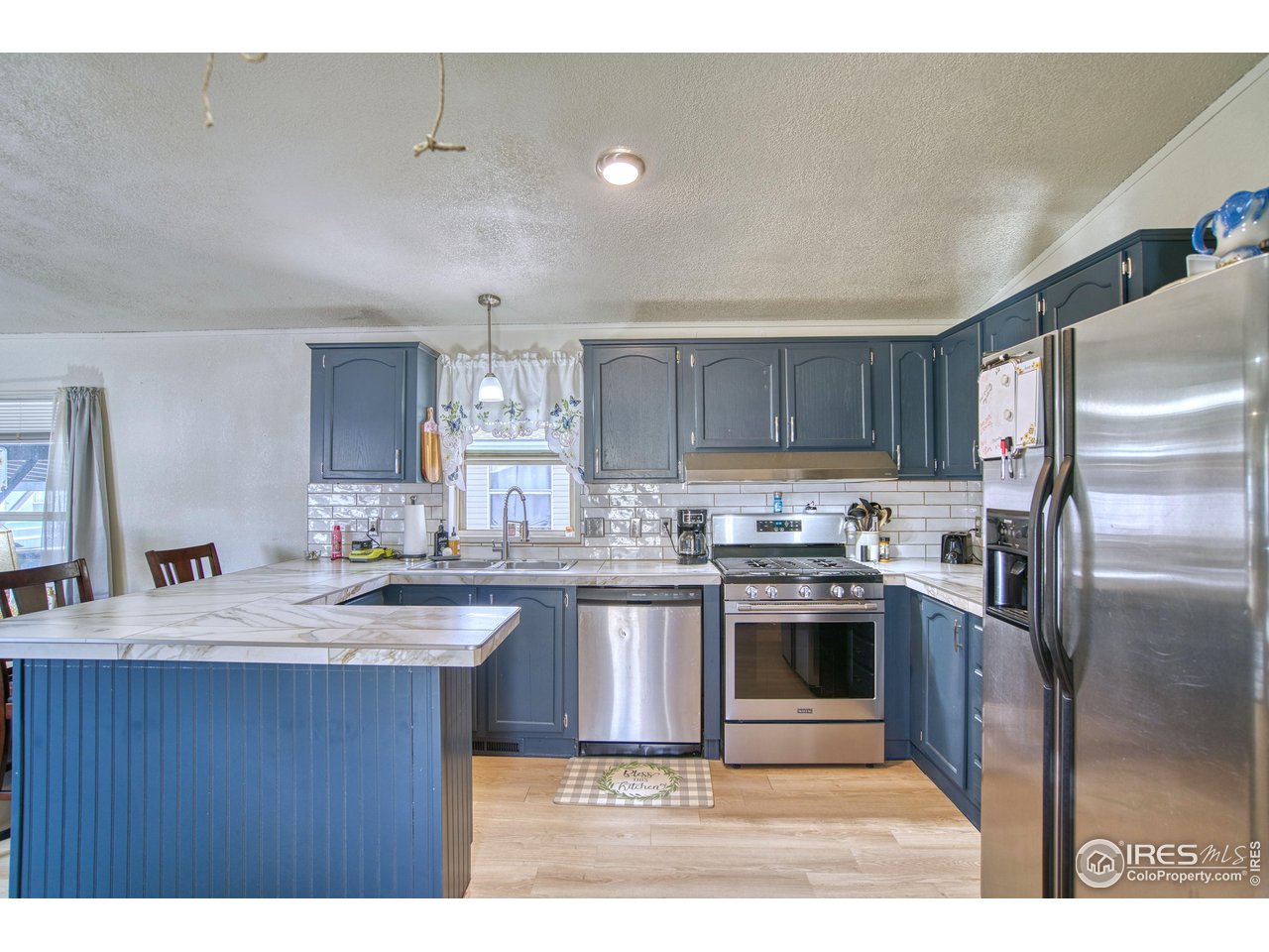 230 North 2nd Street, Unit 26 Berthoud, CO 80513 - Photo 1 of 17 a kitchen with kitchen island a sink stainless steel appliances and cabinets