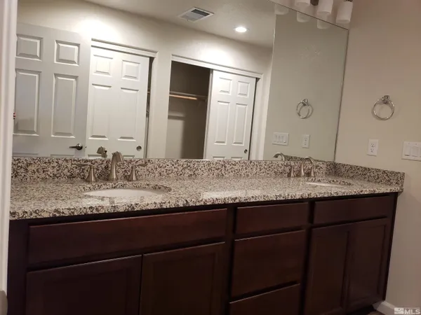 a bathroom with a granite countertop sink and a mirror