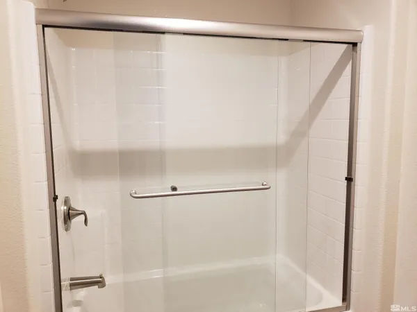a bathroom with a shower and a glass shower door