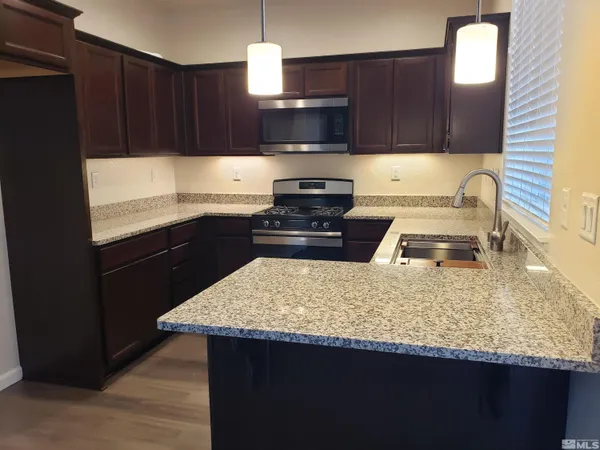 a kitchen with granite countertop wooden cabinets and a granite counter tops