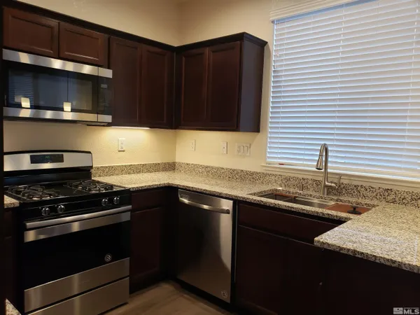 a kitchen with granite countertop a sink and a stove