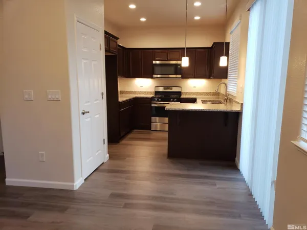 a kitchen with stainless steel appliances granite countertop a refrigerator and a sink