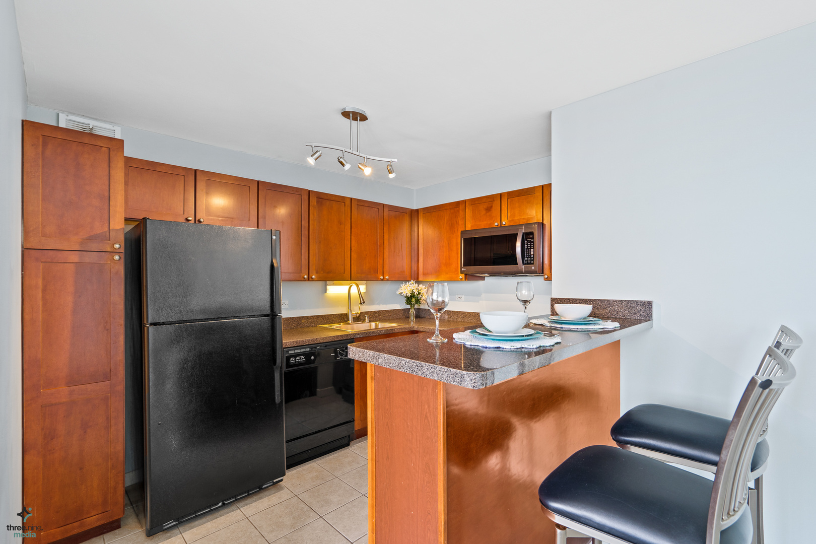 655 West Irving Park Road, Unit 3214 Chicago, IL 60613 - Photo 11 of 37 a kitchen with stainless steel appliances granite countertop a refrigerator a sink a stove a dining table and chairs