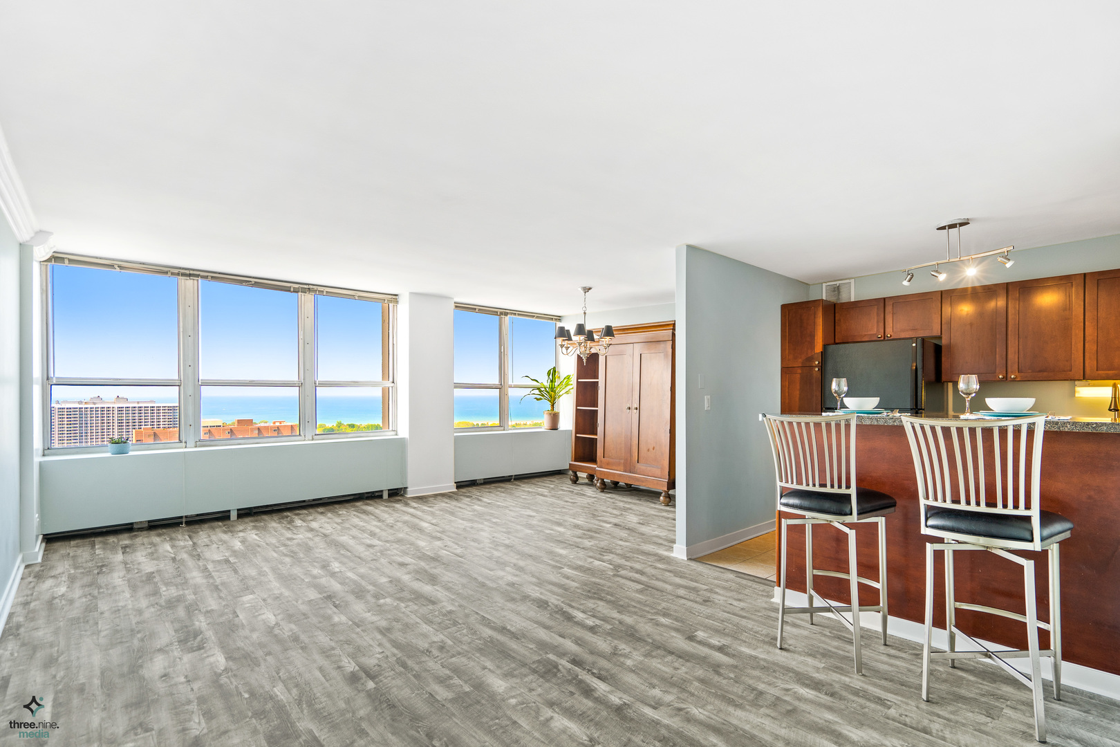 655 West Irving Park Road, Unit 3214 Chicago, IL 60613 - Photo 7 of 37 a view of an empty room with wooden floor and windows