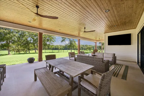 a view of a patio with a table chairs and a backyard