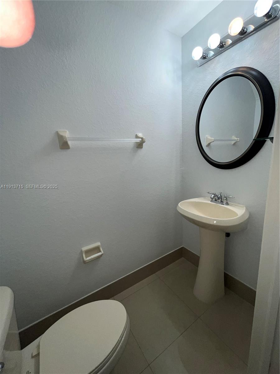 4929 Southwest 140th Terrace, Unit 5 Miramar, FL 33027 - Photo 12 of 42 a bathroom with a sink mirror and toilet