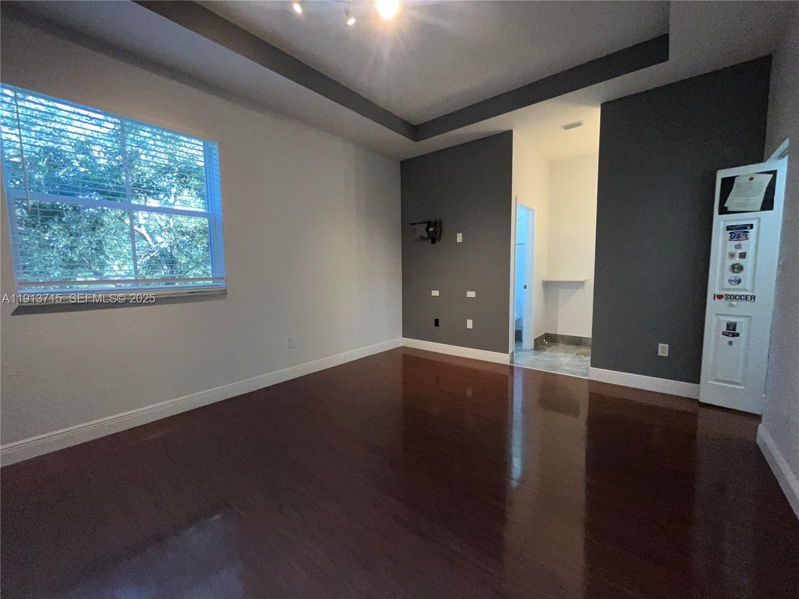 4929 Southwest 140th Terrace, Unit 5 Miramar, FL 33027 - Photo 20 of 42 a view of an empty room with wooden floor and a window