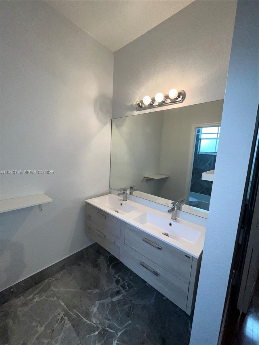 4929 Southwest 140th Terrace, Unit 5 Miramar, FL 33027 - Photo 23 of 42 a bathroom with a double vanity sink and mirror