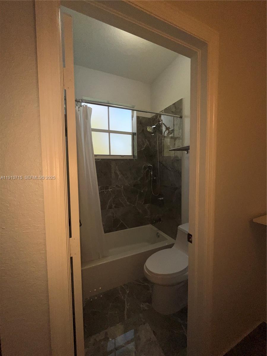 4929 Southwest 140th Terrace, Unit 5 Miramar, FL 33027 - Photo 24 of 42 a bathroom with a shower and toilet