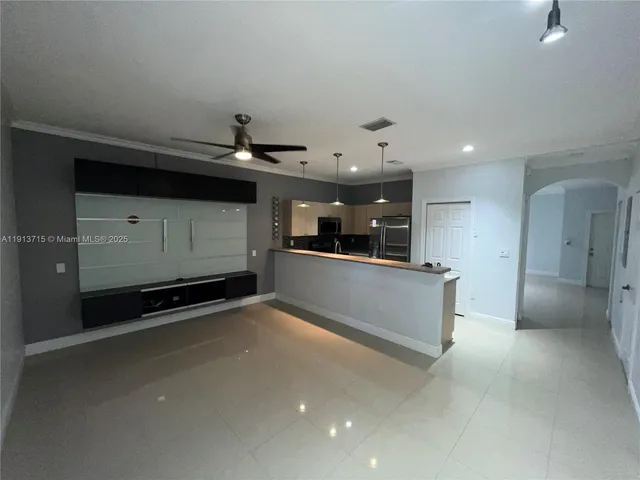 wooden floor in an empty room with a kitchen