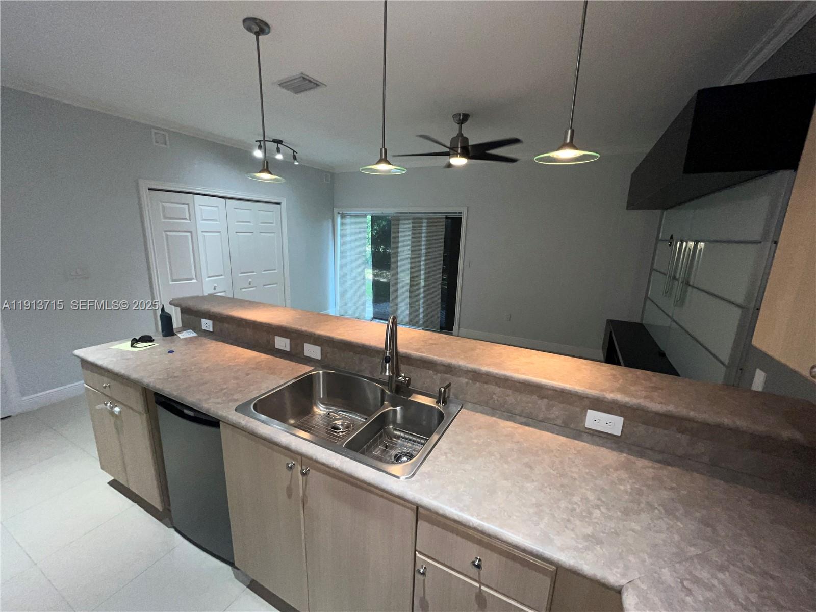4929 Southwest 140th Terrace, Unit 5 Miramar, FL 33027 - Photo 10 of 42 a kitchen with a sink and center island