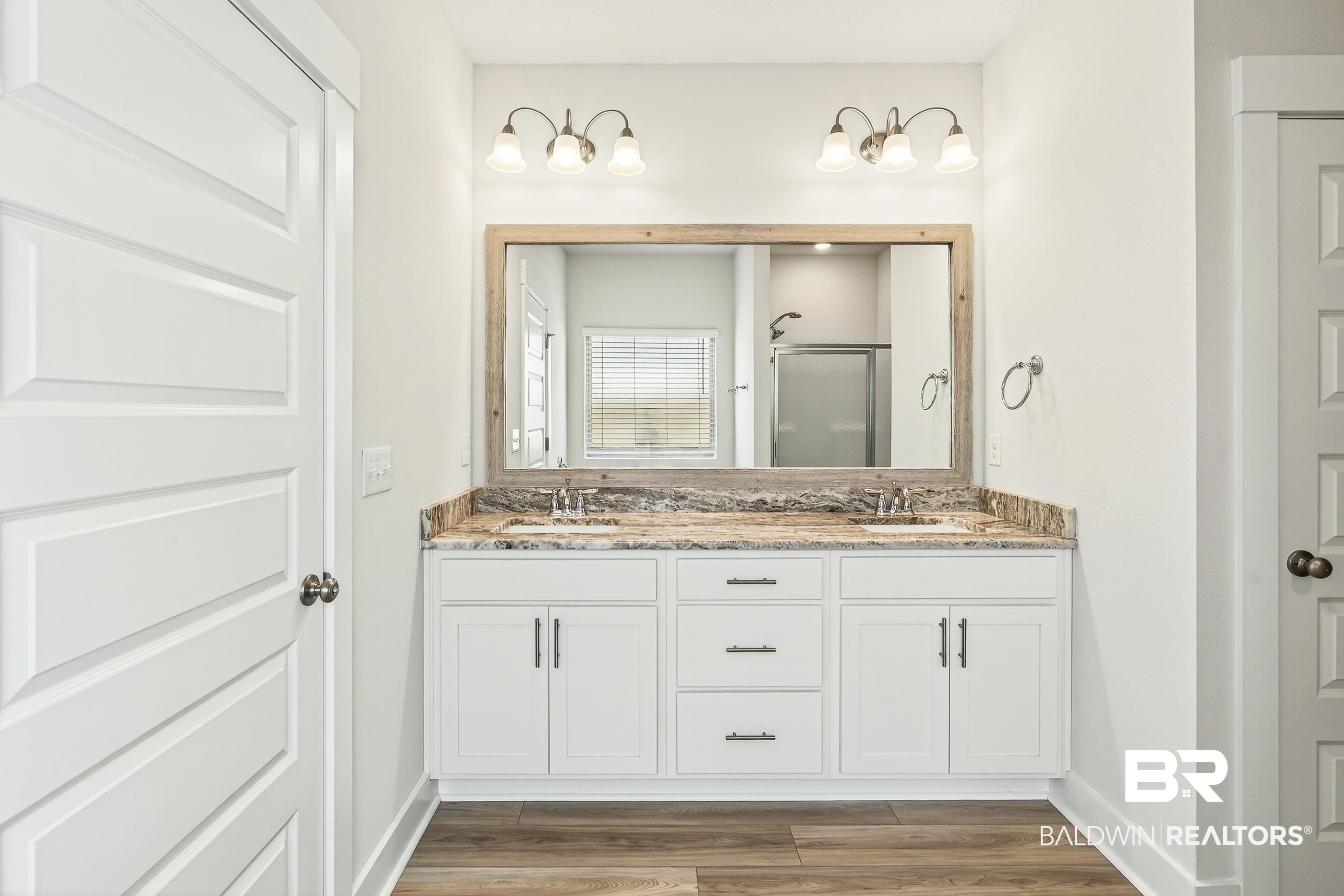1728 Partridge Street Foley, AL 36535 - Photo 25 of 37 Full bathroom with double vanity, a shower stall, and light wood finished floors