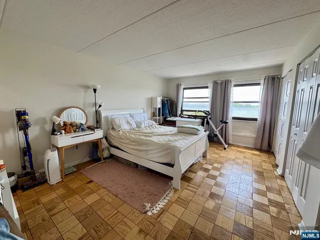 a bedroom with a bed and a dresser next to a window