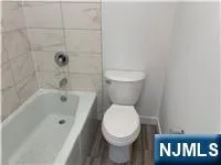 a white toilet sitting next to a bathtub
