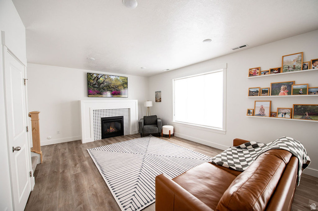 384 Ropelato Drive Nibley, UT 84321 - Photo 8 of 25 Living area featuring wood finished floors and a tiled fireplace