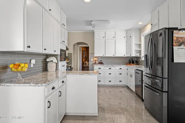 a kitchen with granite countertop white cabinets and appliances