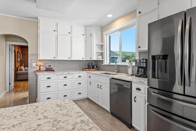 a kitchen with stainless steel appliances a refrigerator sink and cabinets