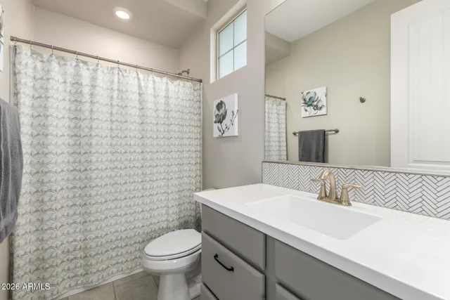 a bathroom with a sink a toilet and shower curtain