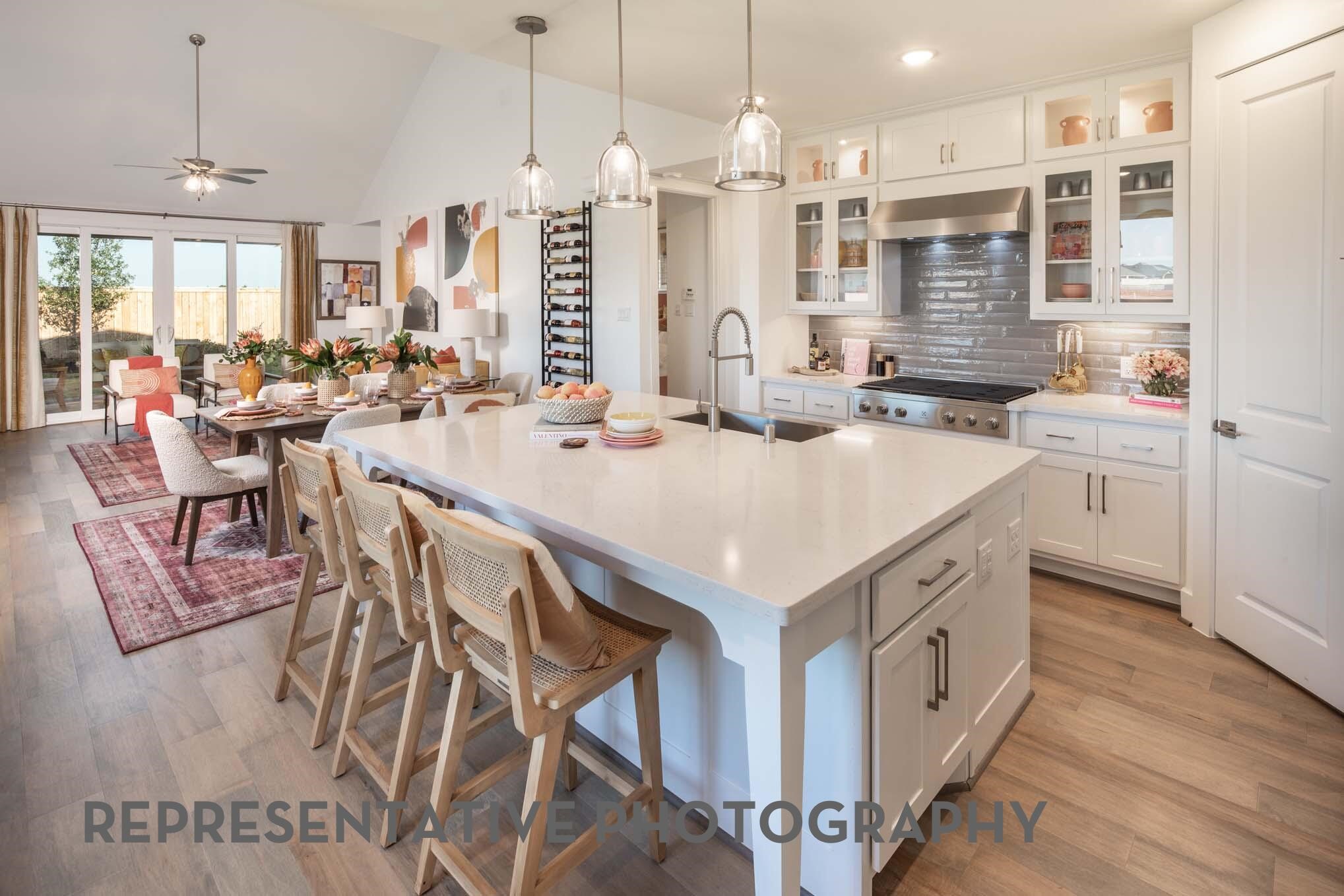 26535 Jolly Prairie Drive Hockley, TX 77447 - Photo 3 of 8 a open kitchen with stainless steel appliances kitchen island granite countertop a stove a sink dishwasher and white cabinets with wooden floor